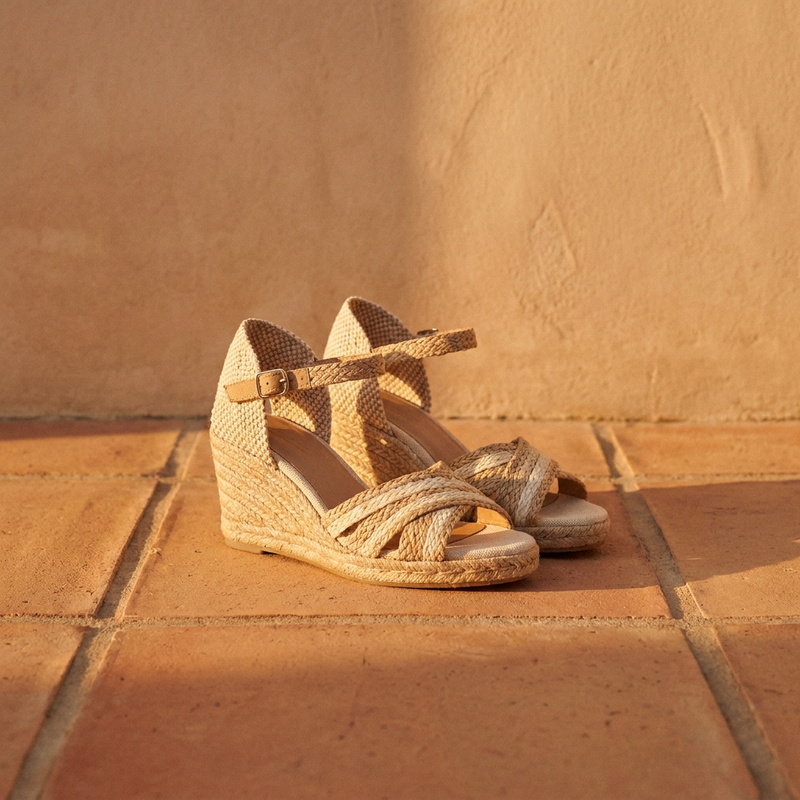 Sandalias de esparto con cuña sobre suelo de baldosas de terracota