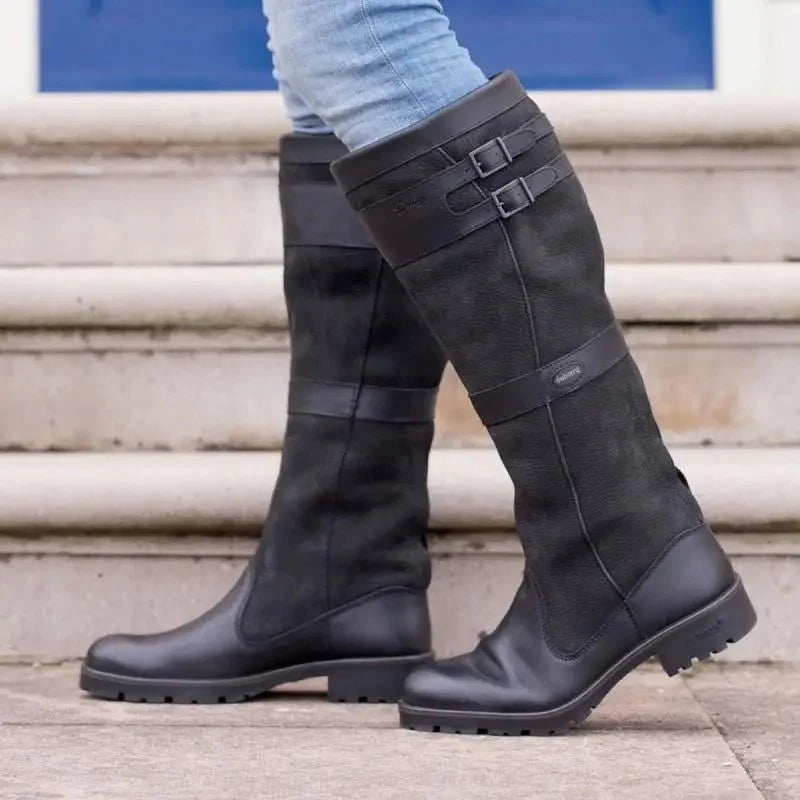 Botas altas de mujer impermeables en negro texturizado, con doble hebilla y ajuste fácil, diseñadas para llegar hasta la rodilla. 1