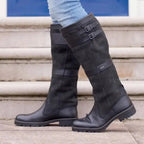 Botas altas de mujer impermeables en negro texturizado, con doble hebilla y ajuste fácil, diseñadas para llegar hasta la rodilla. 1