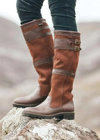 Botas altas de mujer impermeables en negro texturizado, con doble hebilla y ajuste fácil, diseñadas para llegar hasta la rodilla. 2