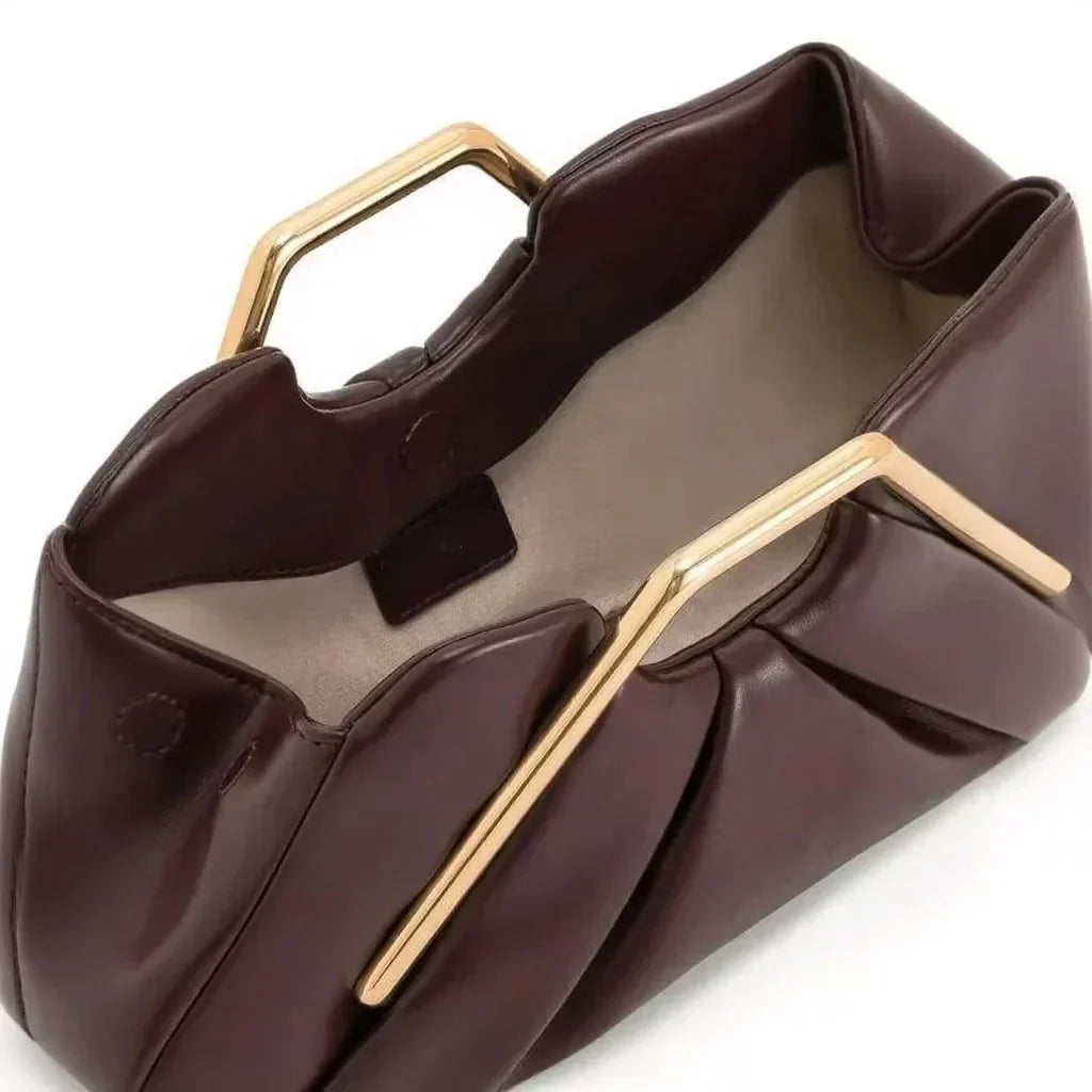 Clutch de piel flexible con asa dorada y diseño origami, elegante accesorio de mano ideal para eventos formales. 2