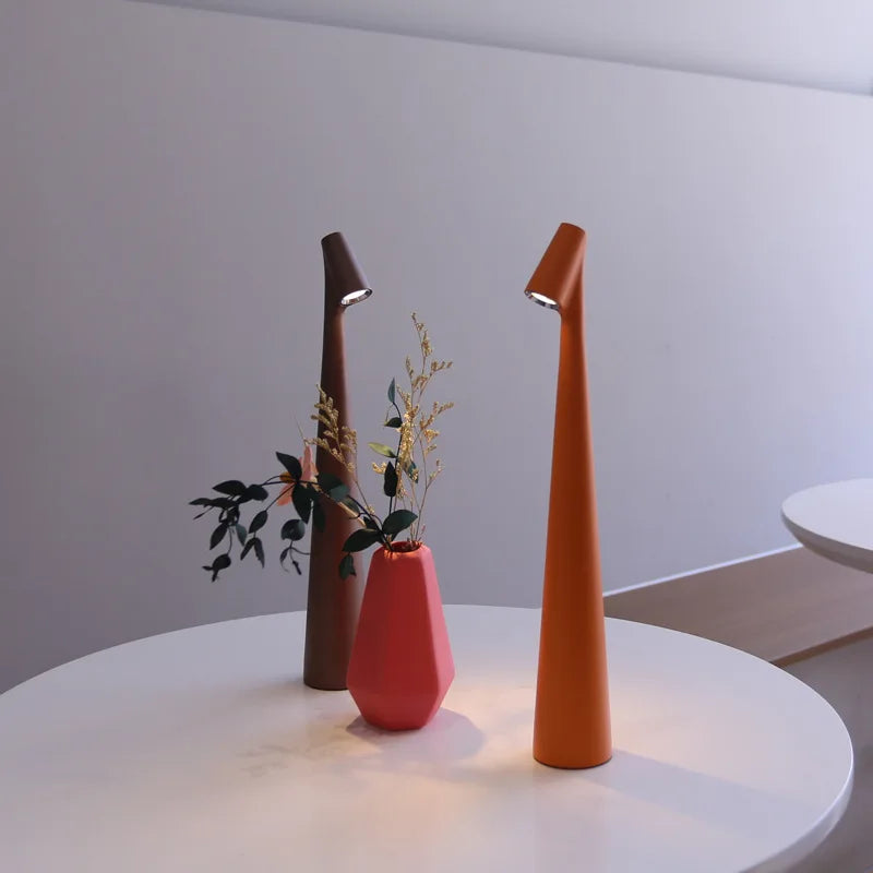 Lámpara de mesa LED regulable con carga USB y control táctil, diseño minimalista y portátil disponible en seis colores vibrantes. 1