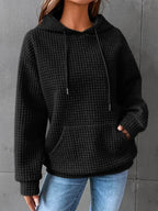 Sudadera mujer negra con capucha ajustable y bolsillo canguro, corte relajado en punto gofrado texturizado. 0