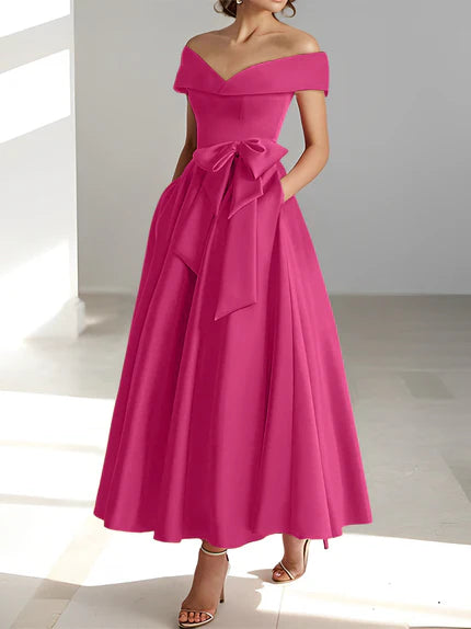 Vestido de madrina de boda en satén fucsia, largo al tobillo, con hombros descubiertos y prácticos bolsillos. 0